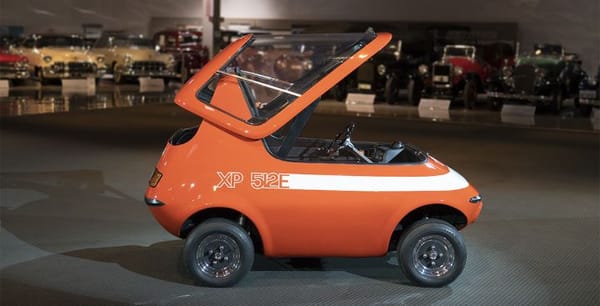 side profile of orange GM XP 512E electric car with its canopy open